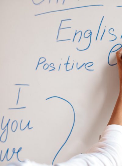 English teacher in mask writing rules on the board